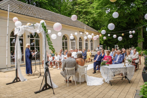 Trouwambtenaar Lilian Oostveen spreekt gasten toe